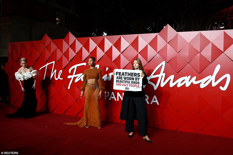 Vick Hope attempted to continue to pose on the carpet alongside the protestor