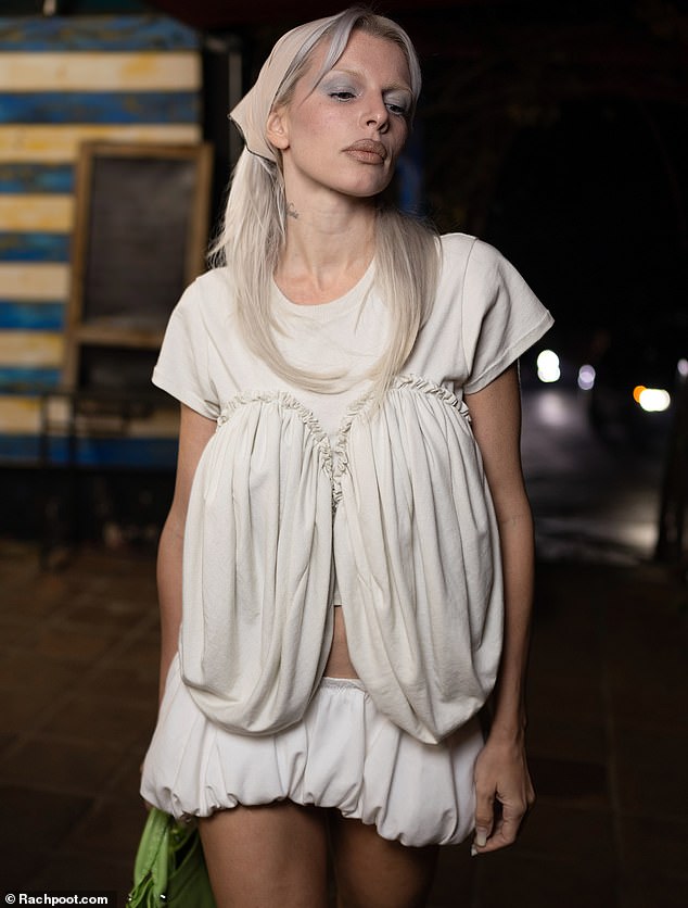 Izoštravajući svoje nepogrešive crte lica teškom šminkom, pustila je svoju pepeljasto plavu kosu da joj slobodno pada preko ramena dok je odlazila na večeru