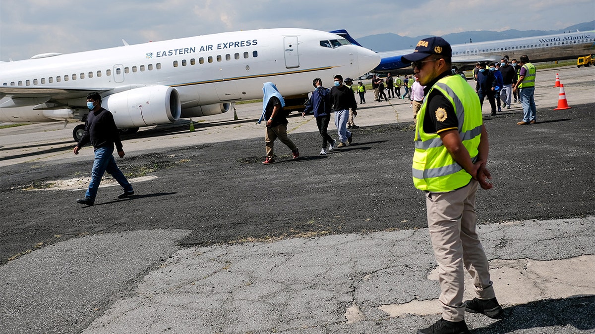 Policajac stoji po strani dok se migranti vraćaju u Gvatemalu.