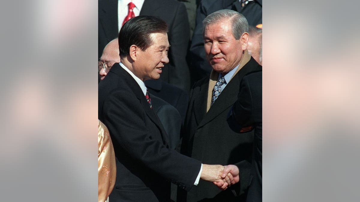 Zatvoreni bivši predsjednik Roh Tae-Woo (desno) gleda kako se južnokorejski novi predsjednik Kim Dae-Jung (lijevo) rukuje sa zatvorenim bivšim predsjednikom Chun Doo-Hwanom (nije na slici) prije polaganja prisege kao predsjednika tijekom ceremonije Inauguracija u Nacionalnoj skupštini u Seulu 25. veljače.