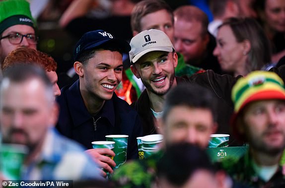 Tottenham Hotspur players Brennan Johnson (left) and James Maddison can be seen watching the third round match between Jonny Clayton and Gerwyn Price on day twelve of the Paddy Power World Darts Championship at Alexandra Palace, London. Picture date: Sunday December 29, 2024. PA Photo. See PA story DARTS World. Photo credit should read: Zac Goodwin/PA Wire.RESTRICTIONS: Use subject to restrictions. Editorial use only, no commercial use without prior consent from rights holder.