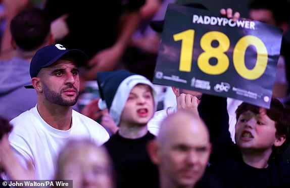 Masnchester City's Kyle Walker (left) during day thirteen of the Paddy Power World Darts Championship at Alexandra Palace, London. Picture date: Monday December 30, 2024. PA Photo. See PA story DARTS World. Photo credit should read: John Walton/PA Wire.RESTRICTIONS: Use subject to restrictions. Editorial use only, no commercial use without prior consent from rights holder.