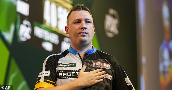 Chris Dobey of England celebrates after winning his round 4 match against Kevin Doets of the Netherlands at the World Darts Championship in London, Monday, Dec. 30, 2024. (AP Photo/Alberto Pezzali)