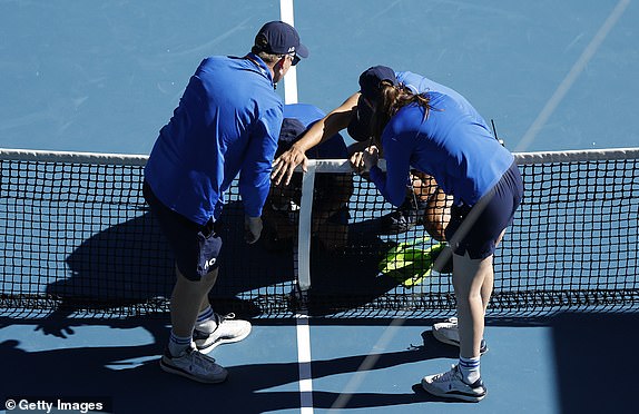 MELBOURNE, AUSTRALIA - JANUARY 14: Technical staffs examine a tv net camera installed on the net smashed by Daniil Medvedev with his racket as he has lost the third set against Kasidit Samrej of Thailand in the Men's Singles First Round match during day three of the 2025 Australian Open at Melbourne Park on January 14, 2025 in Melbourne, Australia. (Photo by Darrian Traynor/Getty Images)