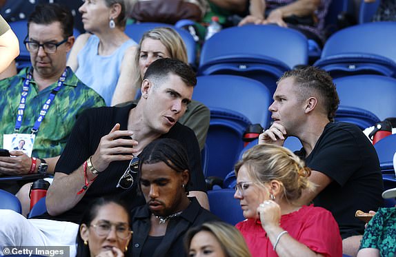 MELBOURNE, AUSTRALIA - JANUARY 14: Australian Rules football player Mason Cox (L) of Collingwood talks with Dan Houston (R) during the Men's Singles First Round between Botic van de Zandschulp of the Netherlands and Alex de Minaur of Australia during day three of the 2025 Australian Open at Melbourne Park on January 14, 2025 in Melbourne, Australia. (Photo by Darrian Traynor/Getty Images)