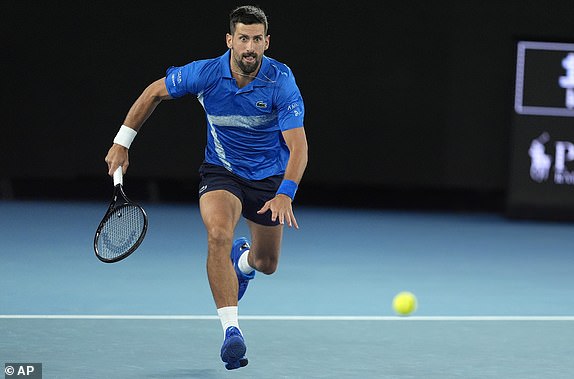 Novak Djokovic of Serbia runs to play a forehand return to Carlos Alcaraz of Spain during their quarterfinal match at the Australian Open tennis championship in Melbourne, Australia, Tuesday, Jan. 21, 2025. (AP Photo/Asanka Brendon Ratnayake)