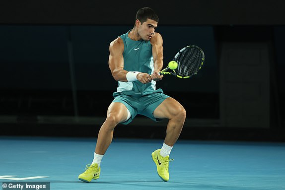 MELBOURNE, AUSTRALIA - JANUARY 21: Carlos Alcaraz of Spain plays a backhand against Novak Djokovic of Serbia in the Men's Singles Quarterfinal match during day 10 of the 2025 Australian Open at Melbourne Park on January 21, 2025 in Melbourne, Australia. (Photo by Cameron Spencer/Getty Images)