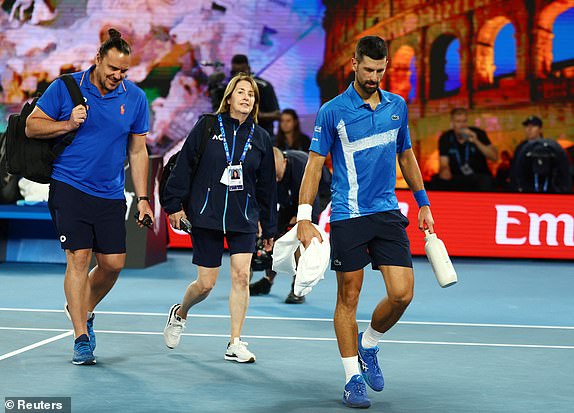 Tennis - Australian Open - Melbourne Park, Melbourne, Australia - January 21, 2025 Serbia's Novak Djokovic walks off the court to receive medical attention after sustaining an injury during his quarter final match against Spain's Carlos Alcaraz REUTERS/Edgar Su