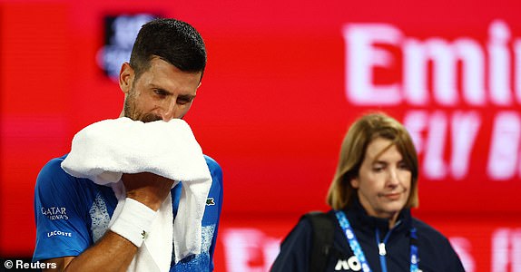 Tennis - Australian Open - Melbourne Park, Melbourne, Australia - January 21, 2025 Serbia's Novak Djokovic walks off the court to receive medical attention after sustaining an injury during his quarter final match against Spain's Carlos Alcaraz REUTERS/Edgar Su