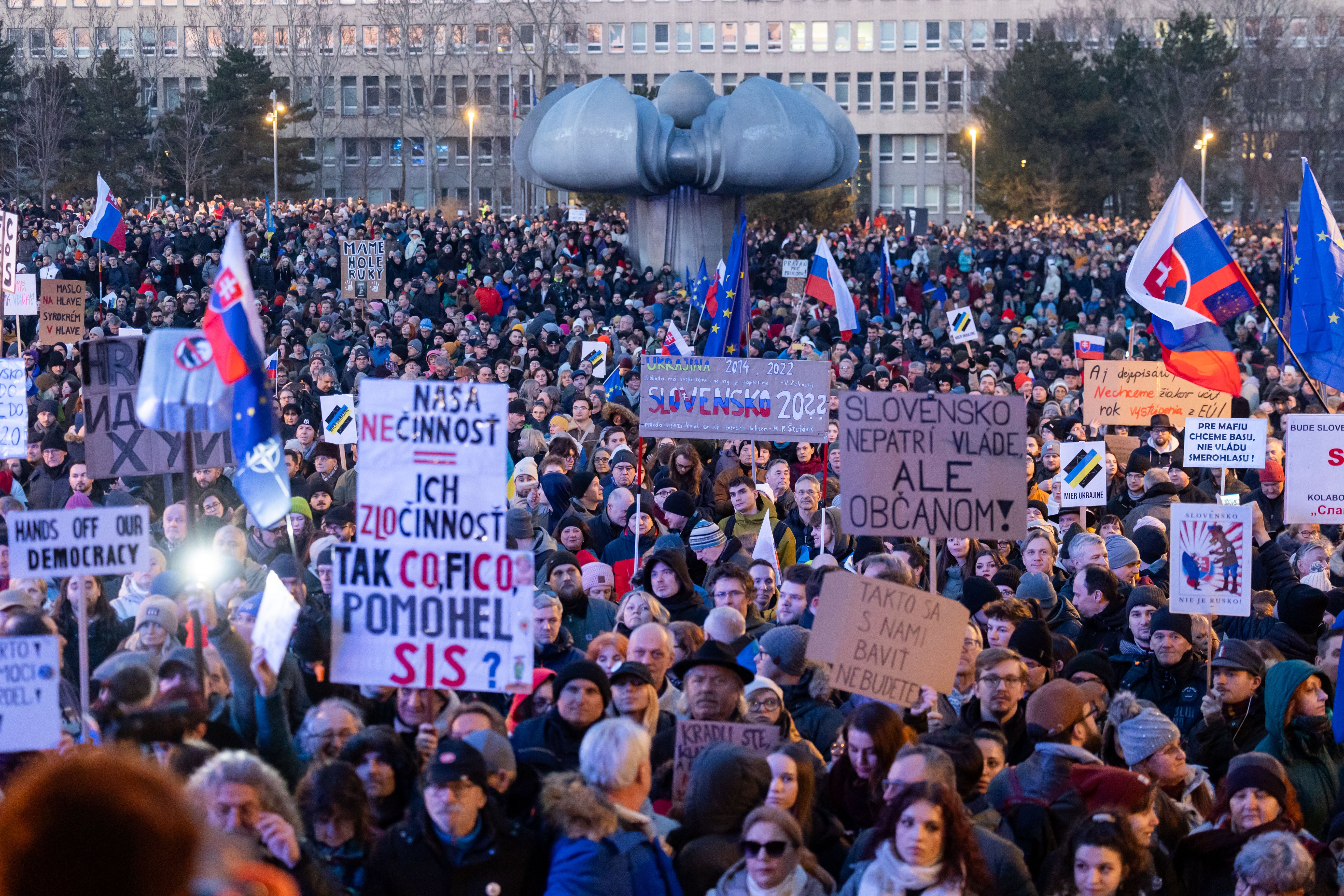 Stotine ljudi drže transparente dok sudjeluju u protuvladinom prosvjedu u Bratislavi u Slovačkoj u petak