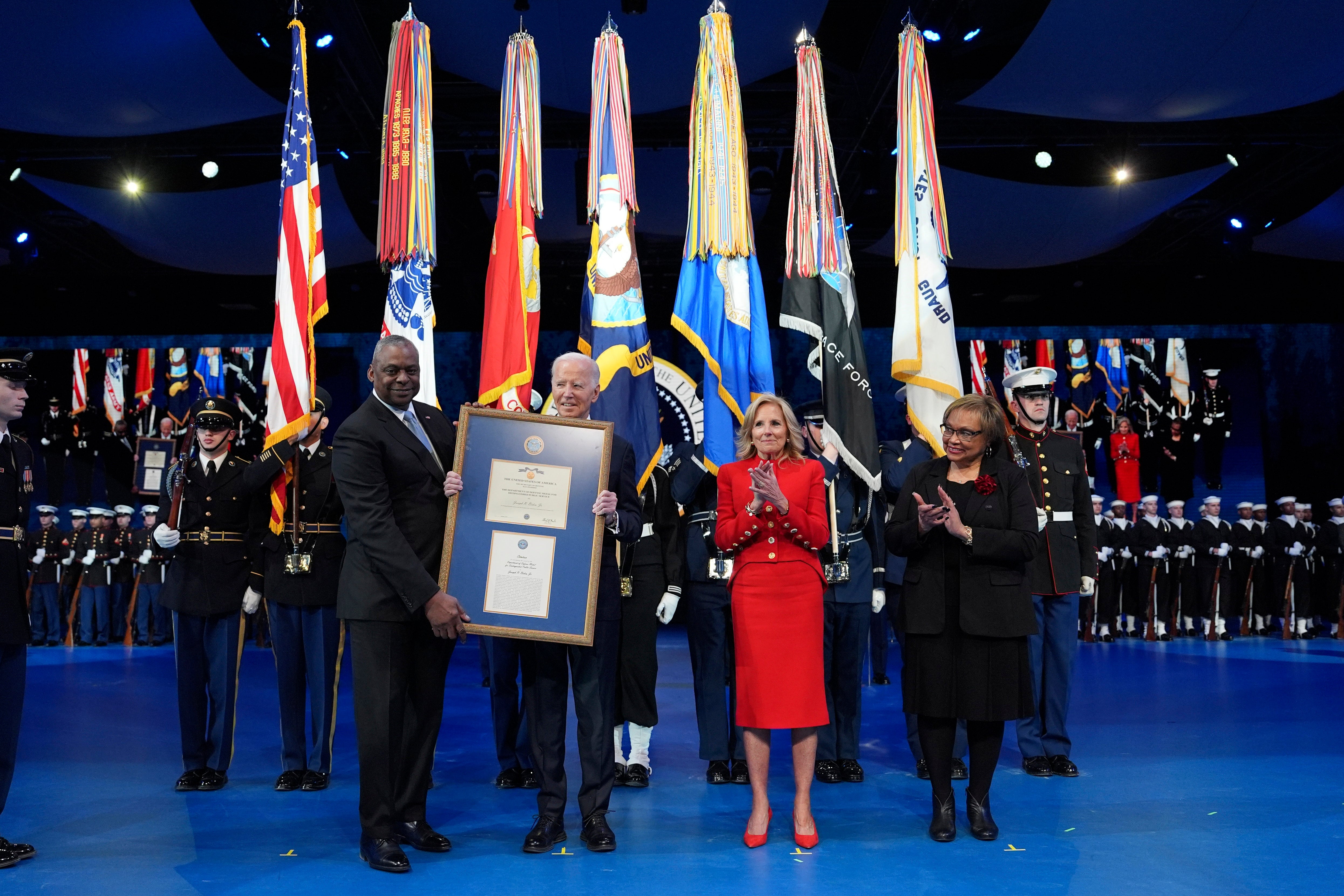 Ministar obrane Lloyd Austin, slijeva, predaje plaketu predsjedniku Joeu Bidenu za medalju za istaknutu javnu službu dok prva dama Jill Biden i Charlene Austin gledaju tijekom ceremonije oproštaja glavnog zapovjednika Ministarstva obrane u zajedničkoj bazi Myer-Henderson Hall