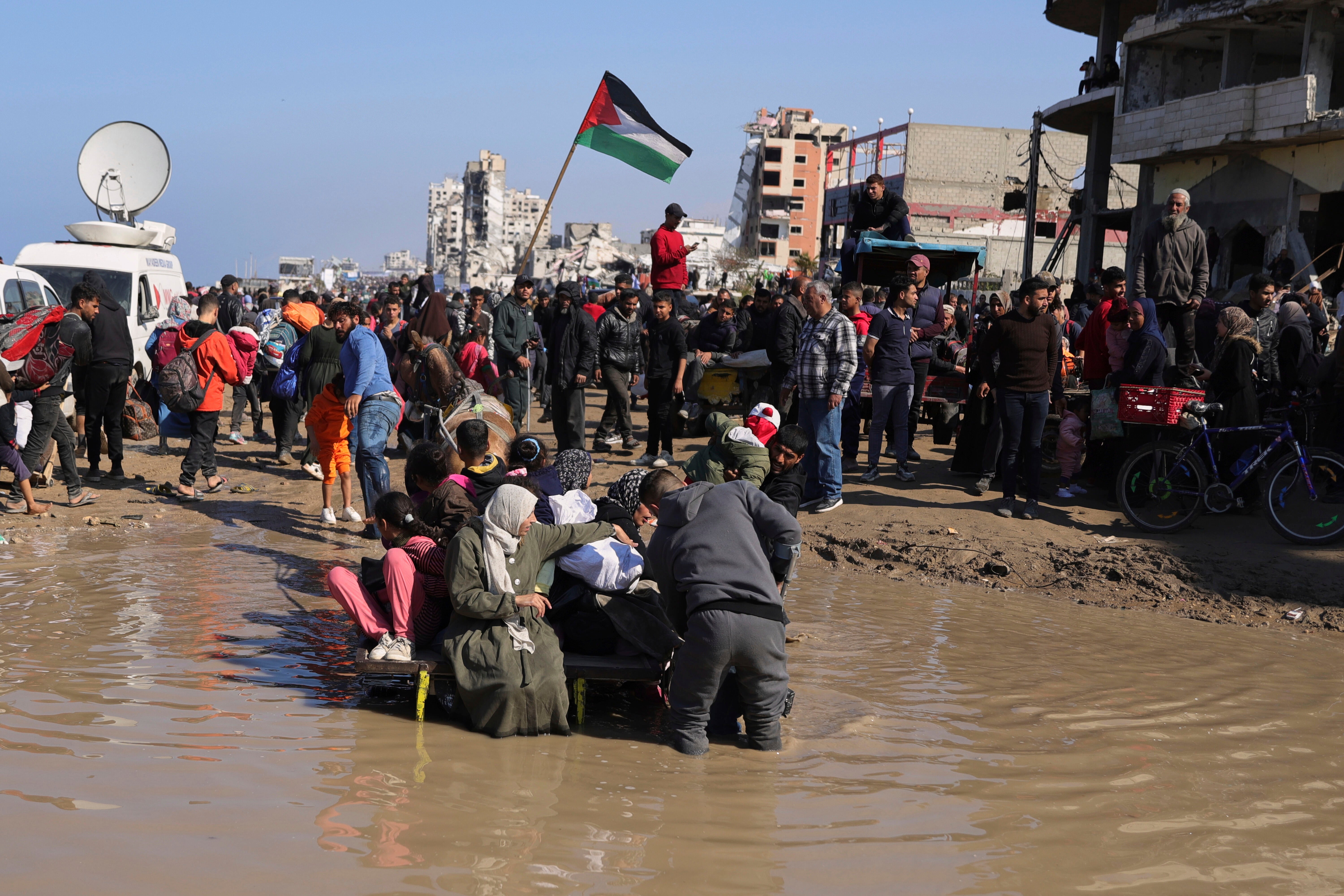 Obitelj na košarici na konju bori se da pređe lokvu vode dok se raseljeni Palestinci vraćaju svojim domovima u traci Sjeverne Gaze