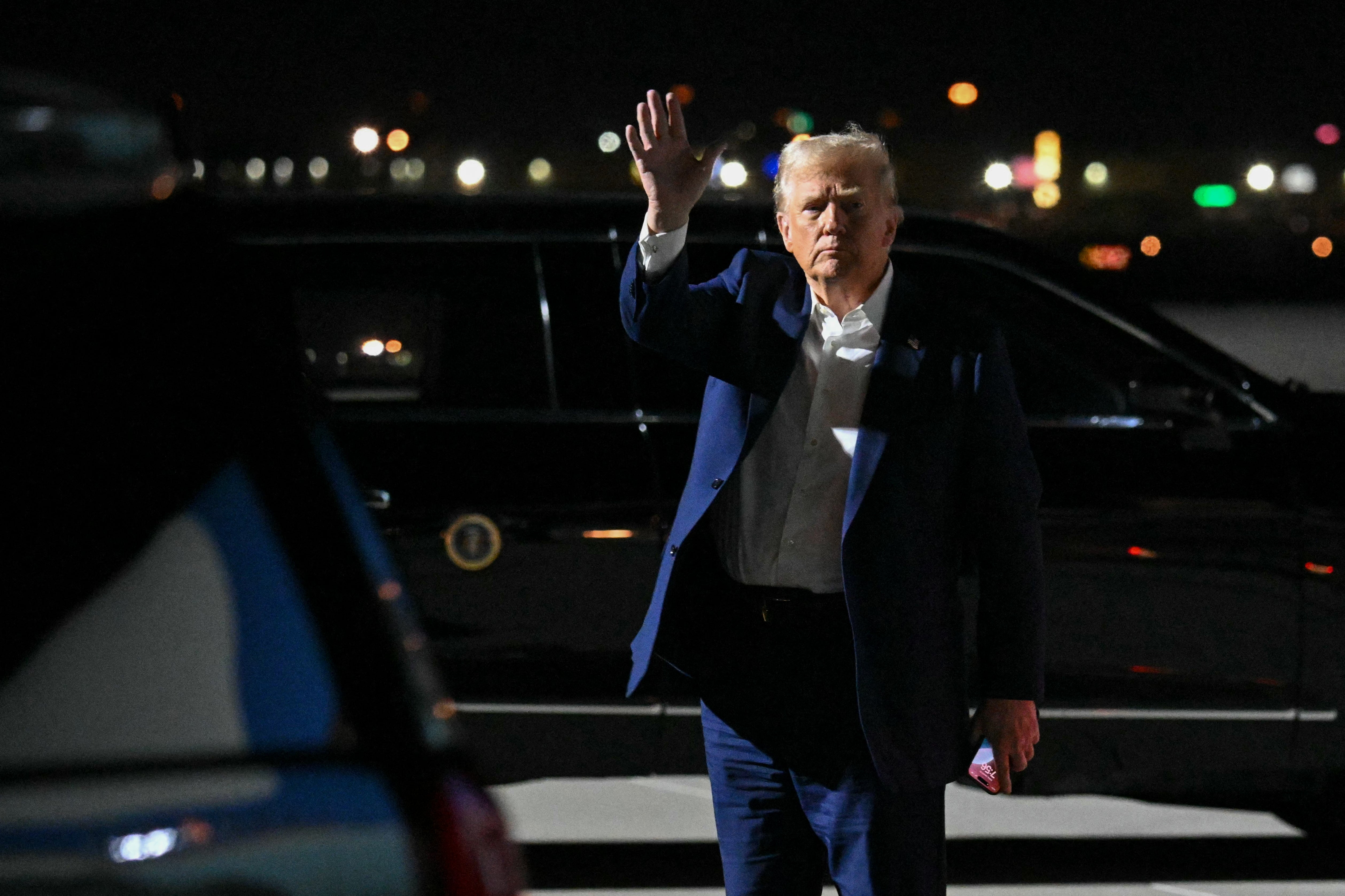 Predsjednik Donald Trump maše nakon što je izašao iz Air Force One po dolasku u međunarodnu zračnu luku Harry Reid u Las Vegasu. U petak navečer otpušta nekoliko vladinih nadzornika