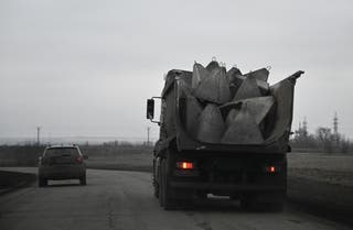 Kamion nosi gomilu betonskih prepreka, poznate kao Zmajevi zubi, na cesti među poljima u regiji Dnipropetrovsk
