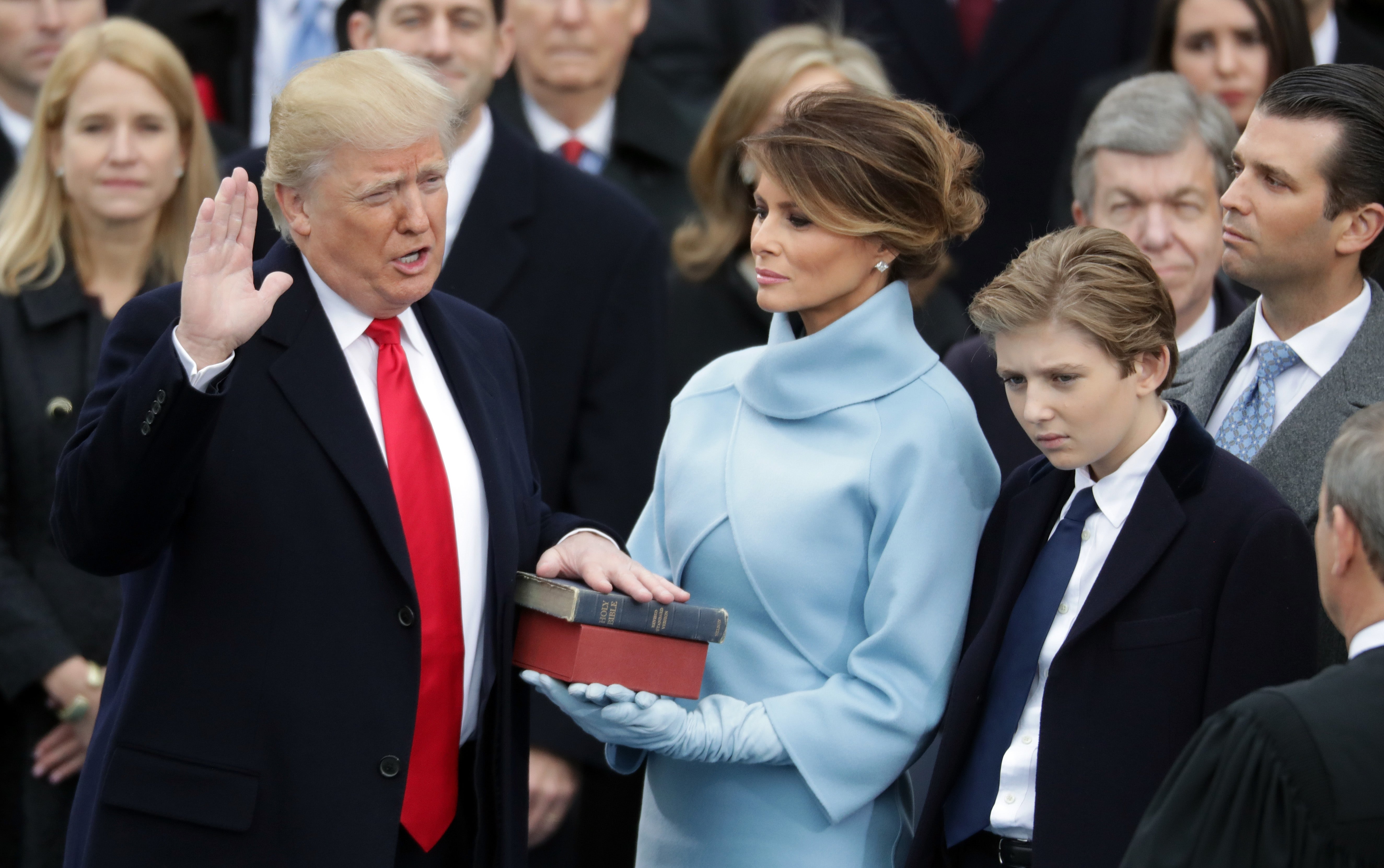 Američki predsjednik Donald Trump polaže zakletvu dok njegova supruga Melania Trump drži bibliju, a njegov sin Barron Trump gleda, na zapadnom pročelju američkog Kapitola 20. siječnja 2017. u Washingtonu, DC. Njegov inauguracijski odbor prikupio je više od 170 milijuna dolara za njegovu sljedeću inauguraciju