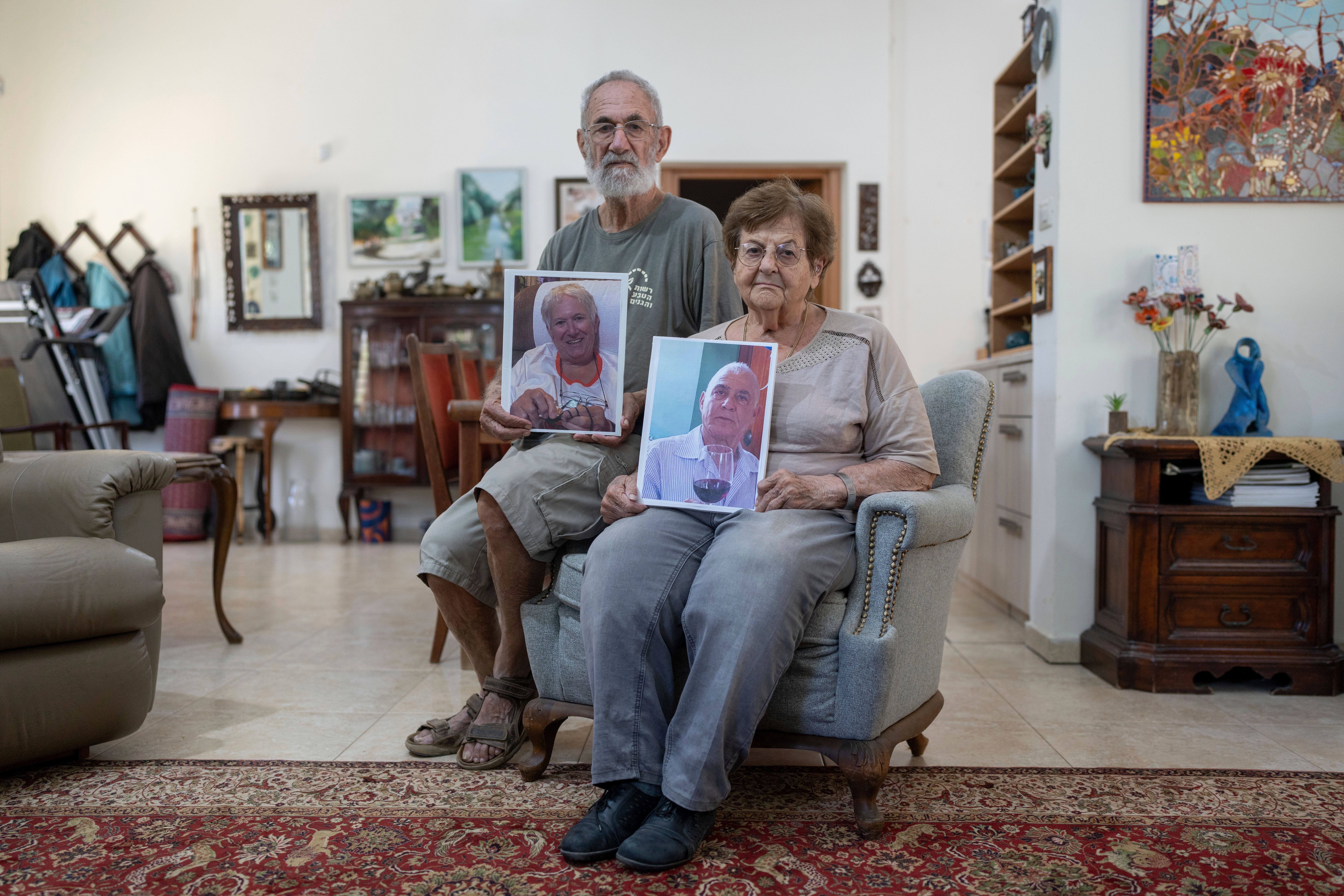 Chanan Choen, zajedno sa svojom suprugom Ednom Choen, drže portrete svoje sestre, 77-godišnje Margalit Moses, i njenog supruga, 79-godišnjeg Gadija Mosesa