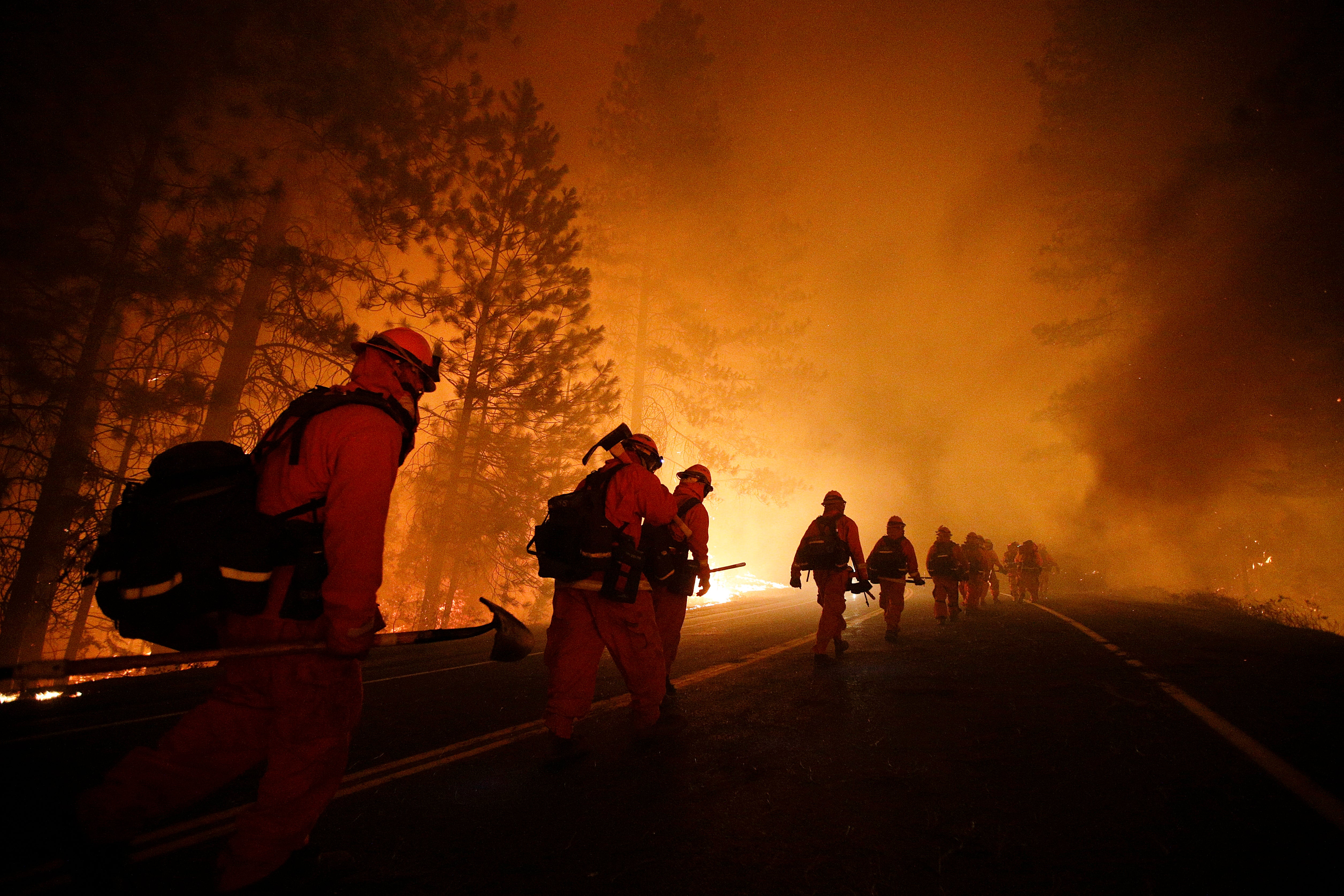 Zatvorenici vatrogasci hodaju duž autoceste 120 nakon operacije izgaranja tijekom požara Rim blizu Nacionalnog parka Yosemite, Kalifornija, 2013. Zatvorske ekipe pomažu u borbi protiv požara koji trenutno haraju Los Angelesom