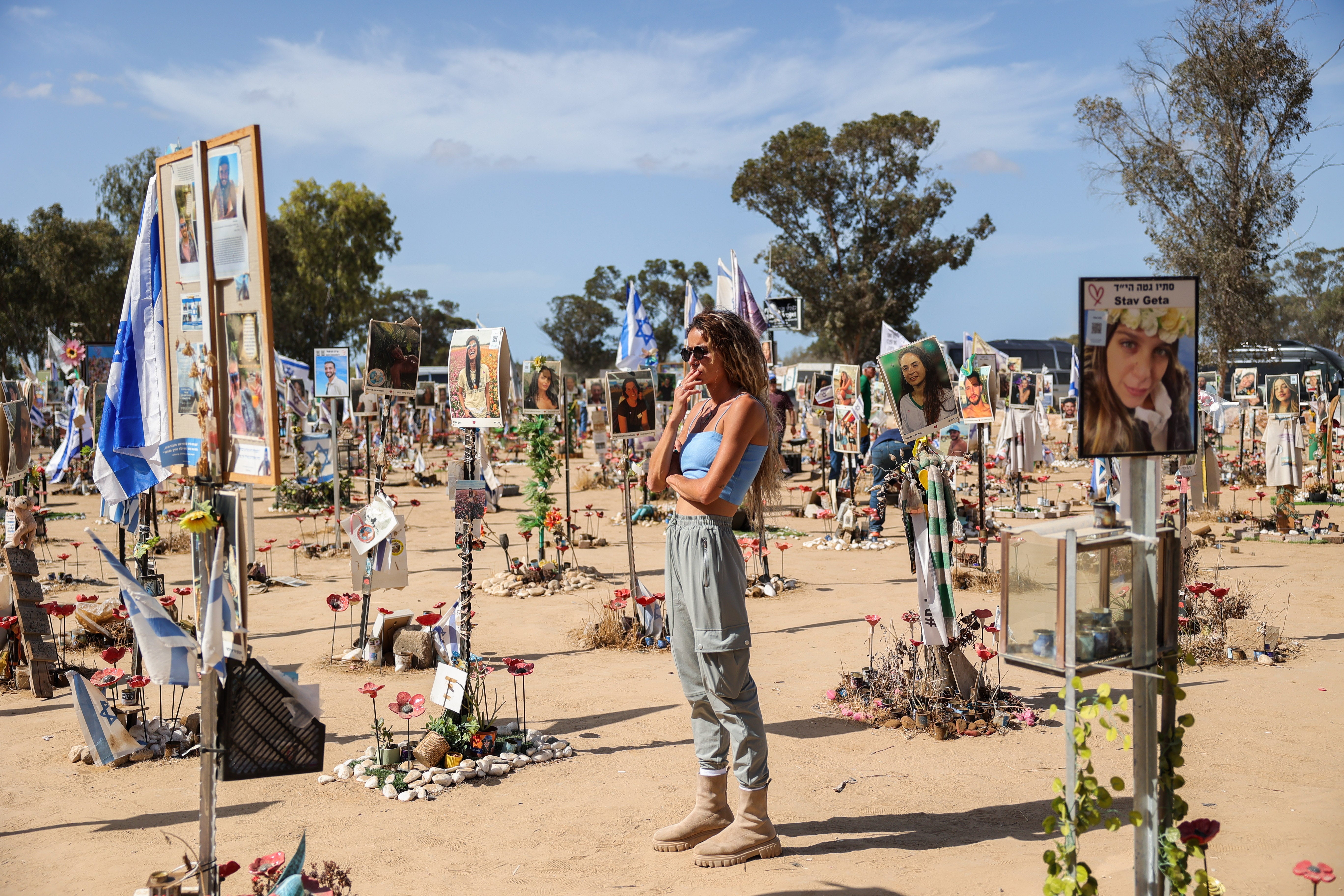 Žena gleda slike i spomenike izraelskim posjetiteljima festivala koje je ubio Hamas na mjestu održavanja glazbenog festivala Supernova