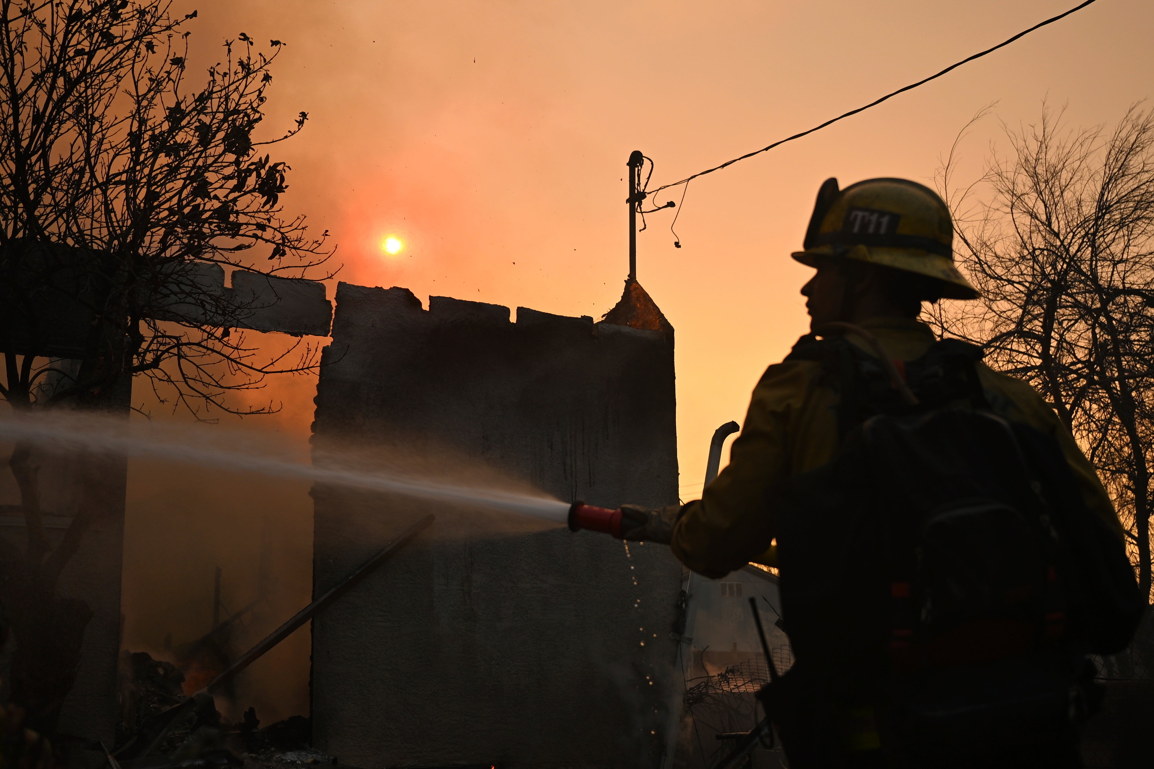 Vatrogasac zalijeva kuću nakon što je izgorio Eaton Fire u Altadeni, Kalifornija. Neki su se zapitali može li se oceanska voda koristiti za gašenje požara