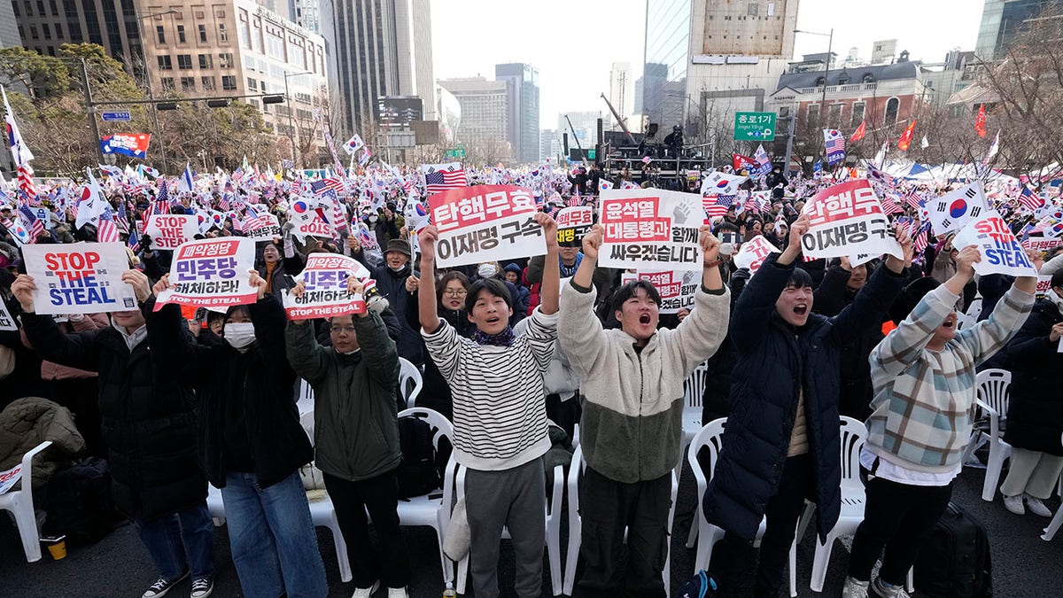 Yoon Suk Yeol pristaše na skupu koji drži natpise