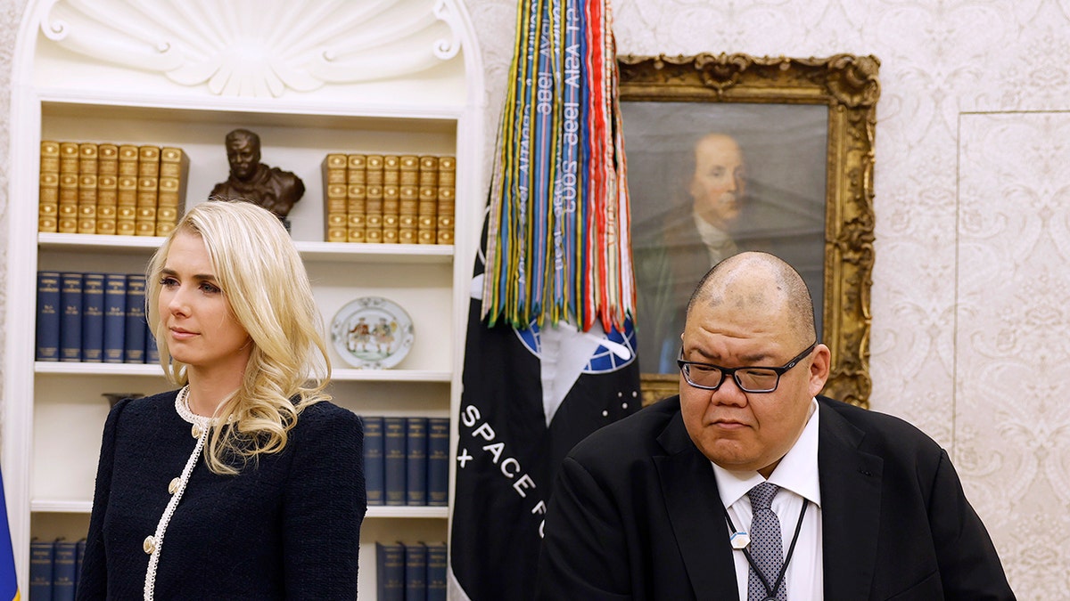 Trump pomaže Natalie Harp i Stephen Cheung slušaju kako predsjednik Trump potpisuje izvršne naredbe u Bijeloj kući.