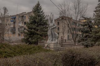 Osoba prolazi pokraj stambenih zgrada jako oštećene granatiranjem u Lymanu, regiji Donjecsk, 1. veljače 2025.