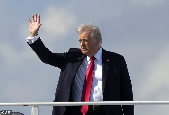President Donald Trump, left, waves as he boards Air Force One with grandson Theodore, Ivanka Trump's son, at Palm Beach International Airport in West Palm Beach, Fla., Sunday, Feb. 9, 2025. (AP Photo/Ben Curtis)