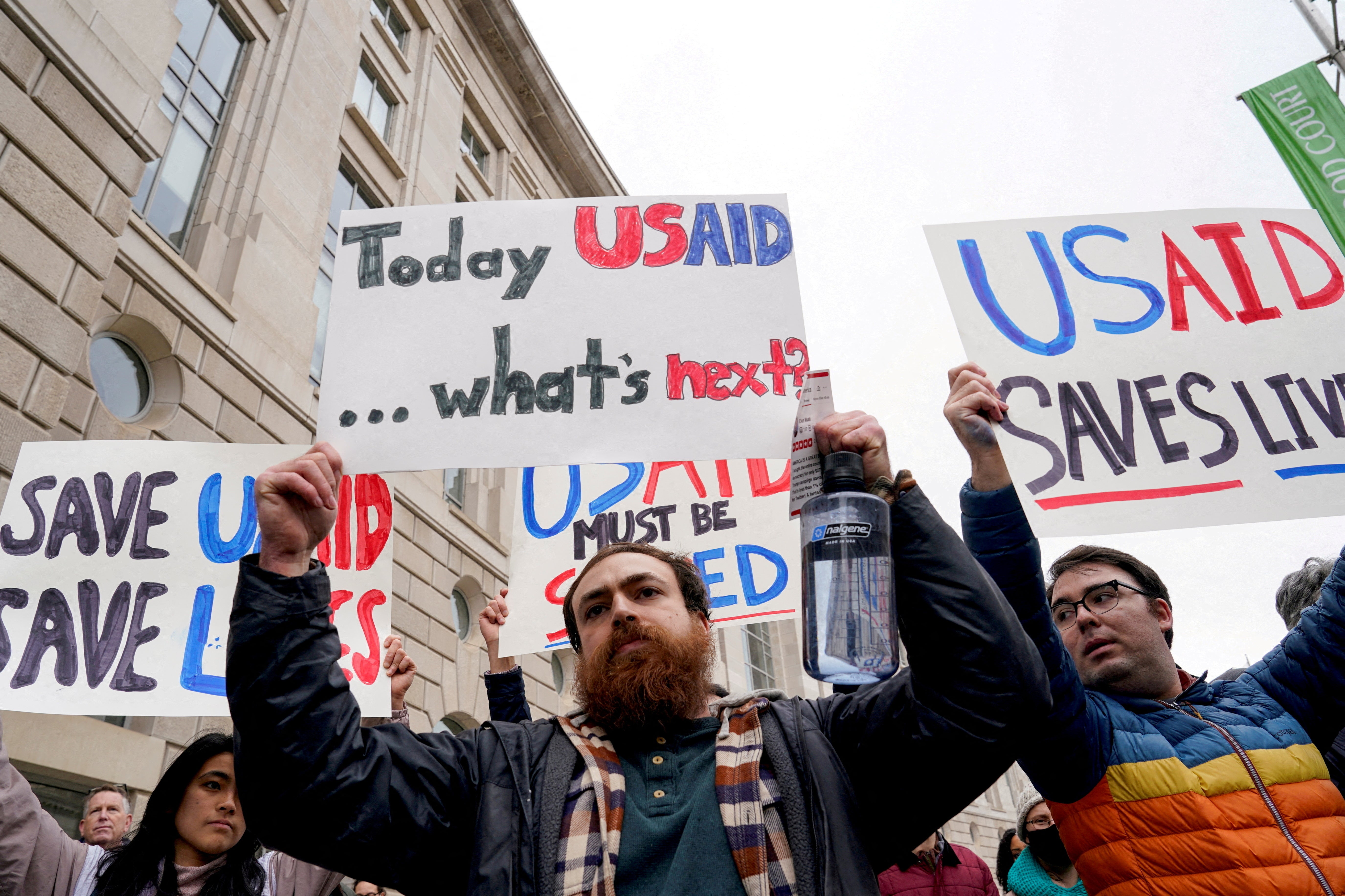 Ljudi drže plakate izvan USAID zgrade