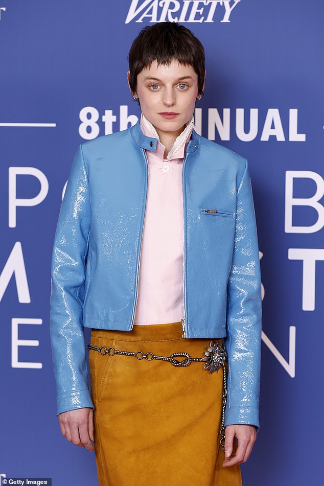 U međuvremenu, Emma je nanijela dječju ružičastu košulju i midi suknju od hrđe narančaste, koju su udružili s sjajnom kožnom plavom jaknom