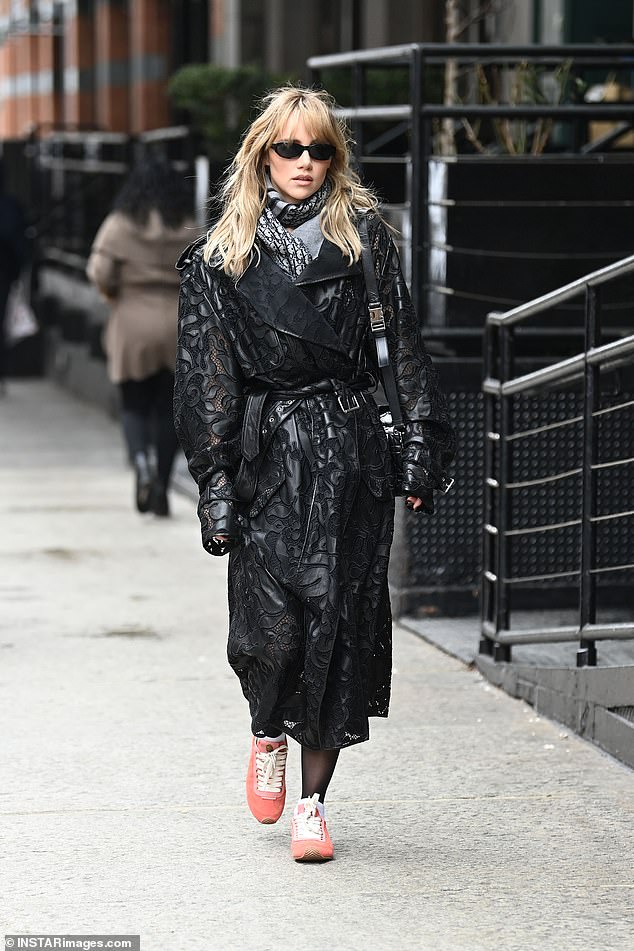 Kako bi dovršio svoj izgled, ona je ubacila svoje osnovne stvari u prekrivenoj mini crnoj vrećici s križanjem tijela i dodala par hladnih pravokutnih sunčanih naočala