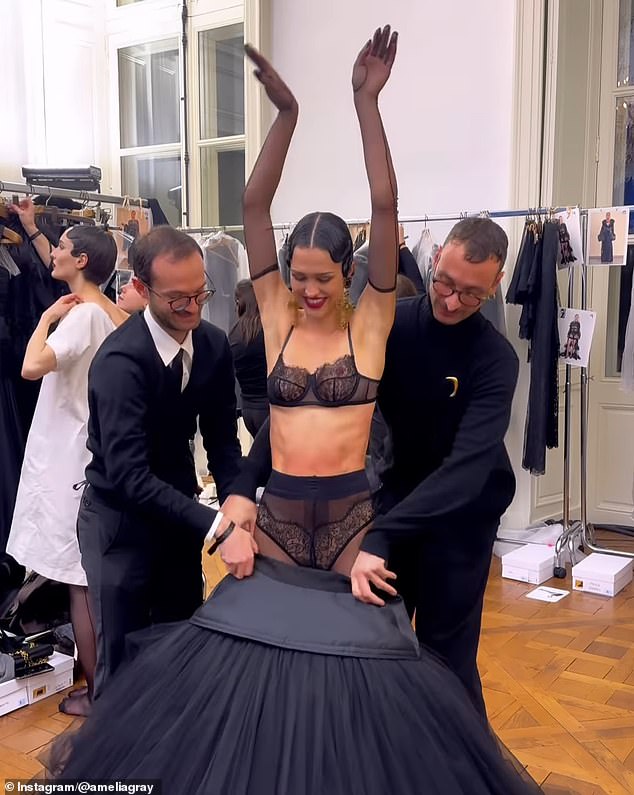 Izgledala je zabavljeno dok ju je jedan muškarac podigao, a drugi je otvorio struk velike suknje