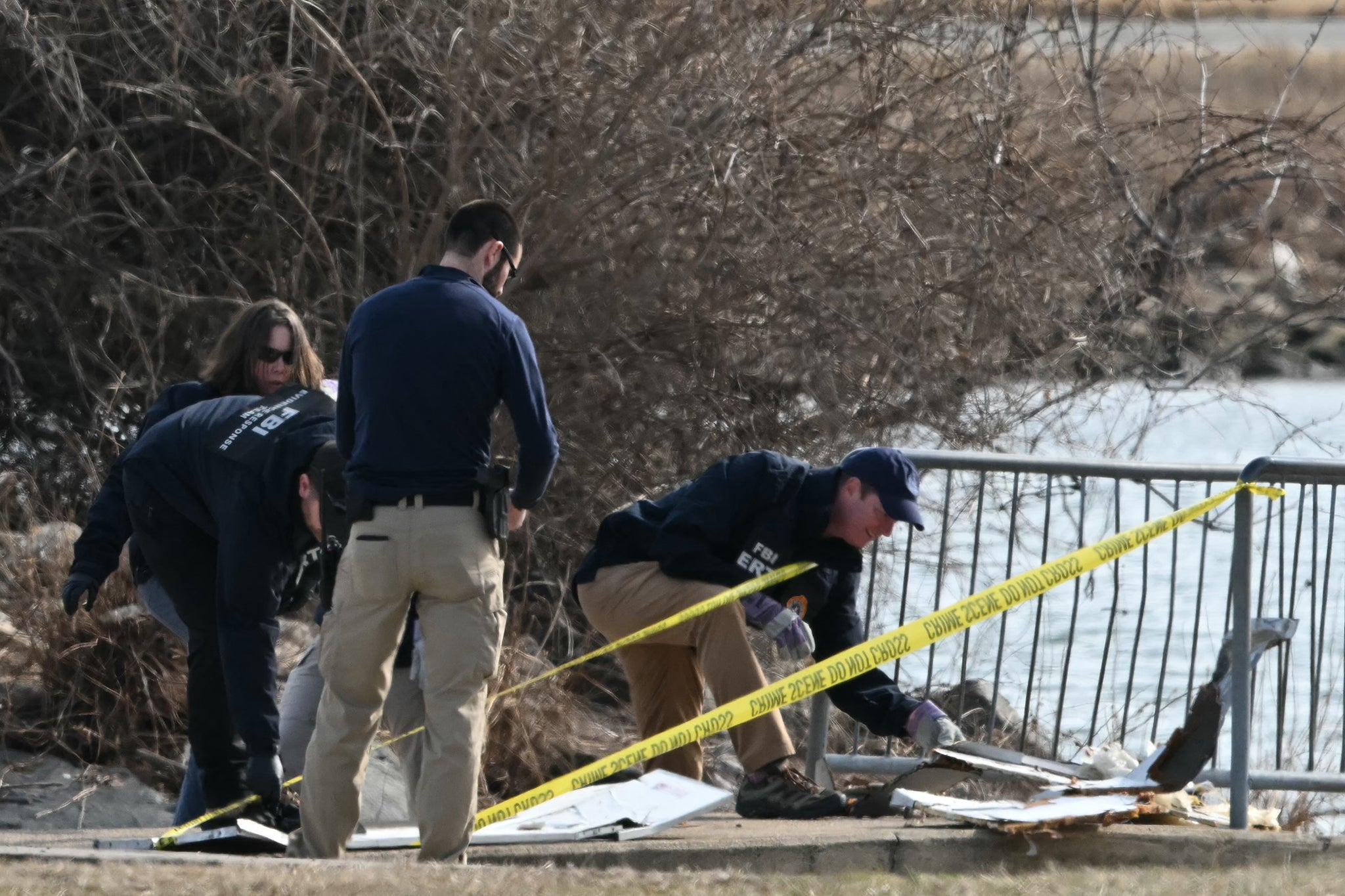Investigators gather pieces of wreckage along the Potomac River