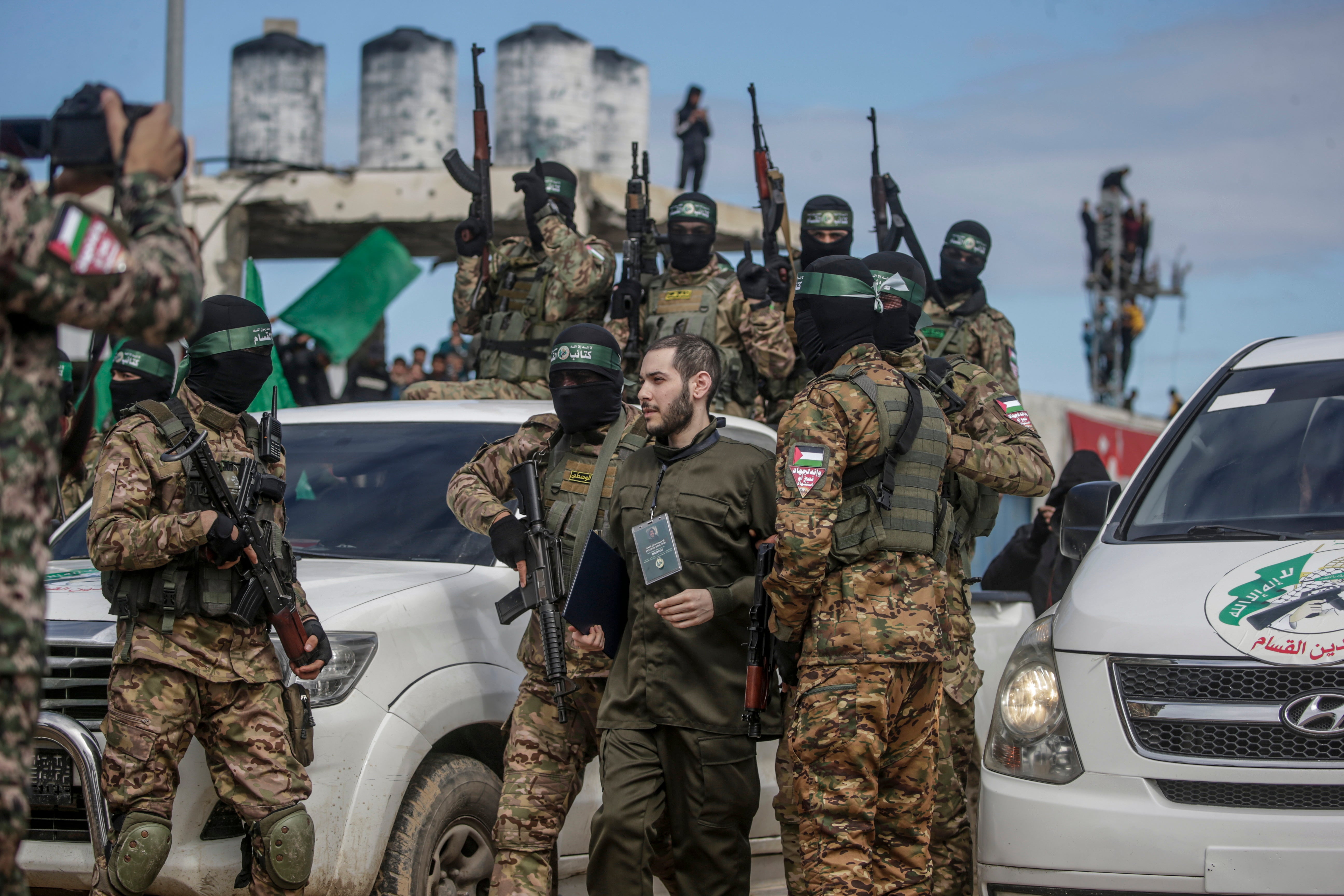 Borci iz Hamasove izz ad-din al-Qassam brigade prate Izraelski talac Eliya Cohen prije nego što su ga predali Crvenom križu u izbjegličkom kampu Al Nusairat