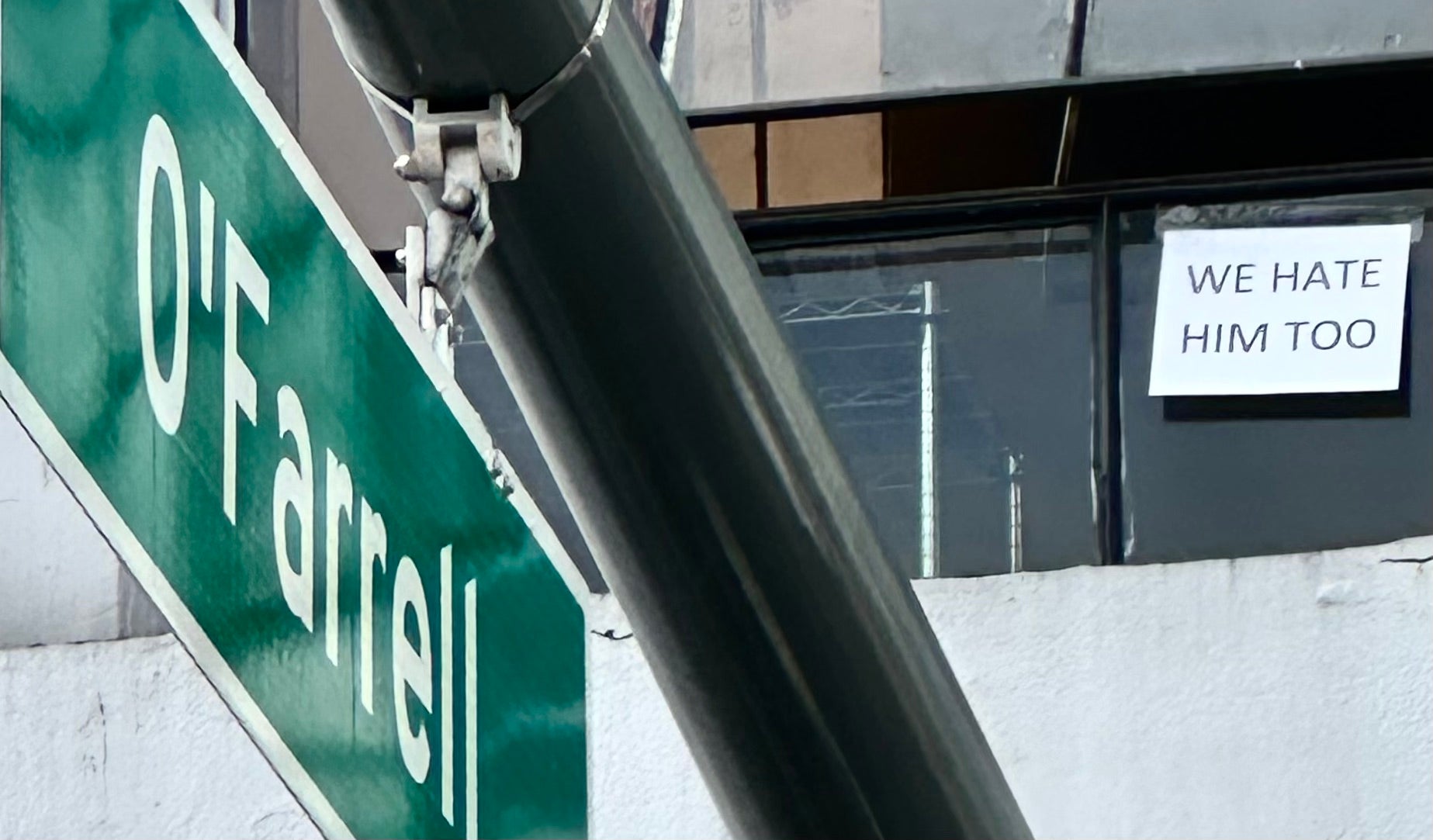 Prijavite se u prozoru iznad Tesle izložbenog salona u San Franciscu tijekom prosvjeda predsjednika