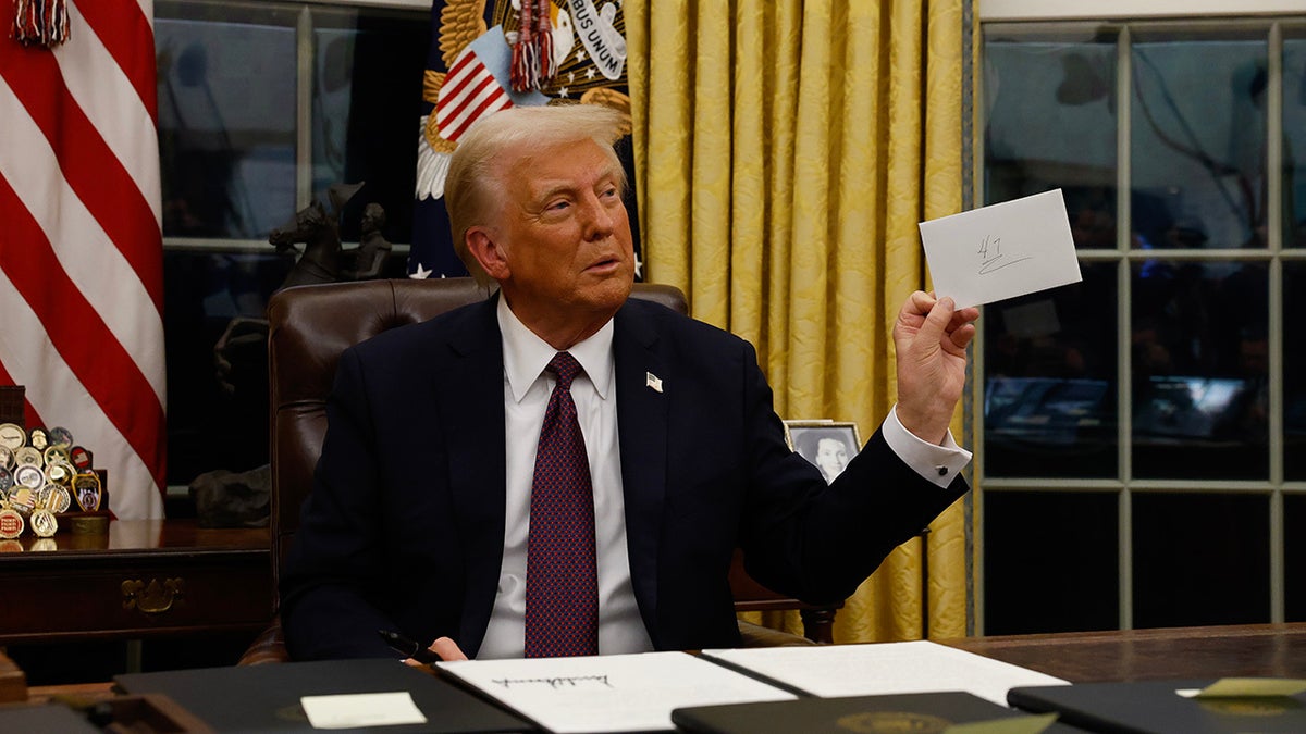 Donald Trump u Ovalnom uredu drži bilješku od Joea Bidena