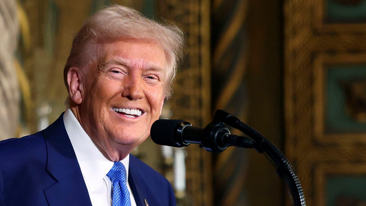 Donald Trump se nasmiješi na postolju