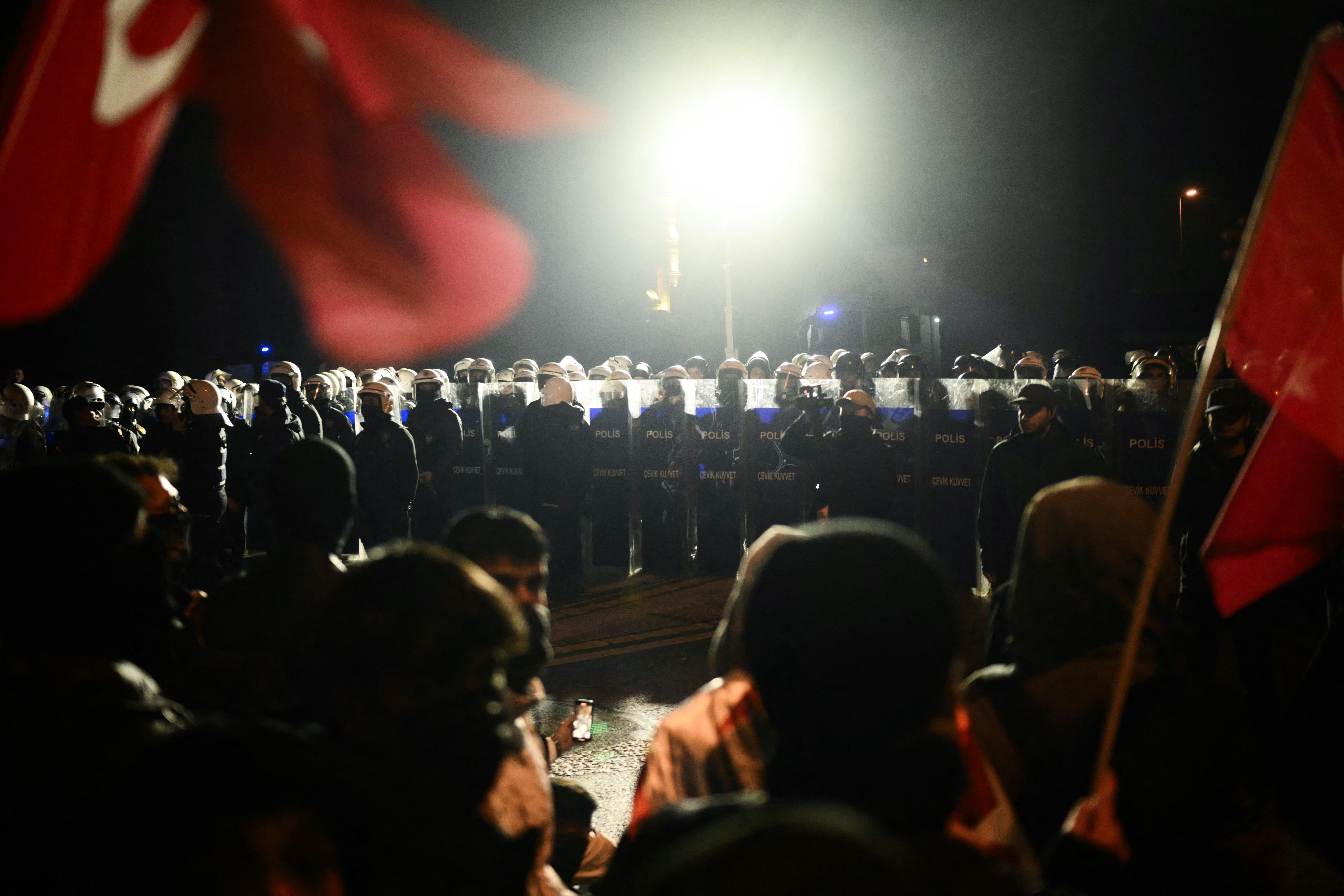 Prosvjednici koji drže turske zastave stoje ispred turskih policajca u neredu u blizini akvadukta Valensa