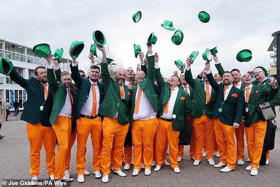 Racegoers in Irish fancy dress throw their hats into the air on day three of the 2025 Cheltenham Festival at Cheltenham Racecourse. Picture date: Thursday March 13, 2025. PA Photo. See PA story RACING Cheltenham. Photo credit should read: Joe Giddens/PA Wire.RESTRICTIONS: Use subject to restrictions. Editorial use only, no commercial use without prior consent from rights holder.