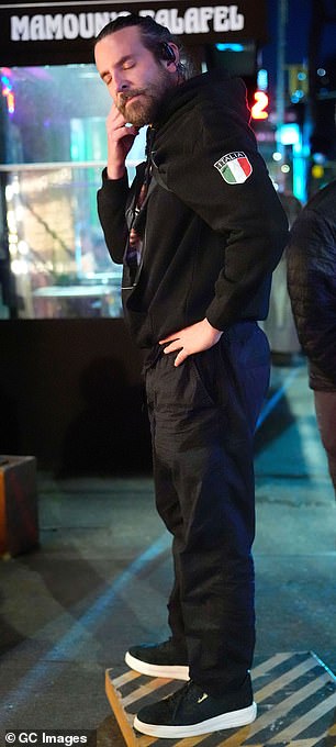 Udobno se držao u crnoj jakni s kapuljačom s značkom Italia, udružen s par crnih hlača i treniranja platforme