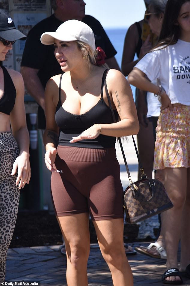 Majka jedne pristupe s malom smeđom torbom s remenom zlatnog lanca