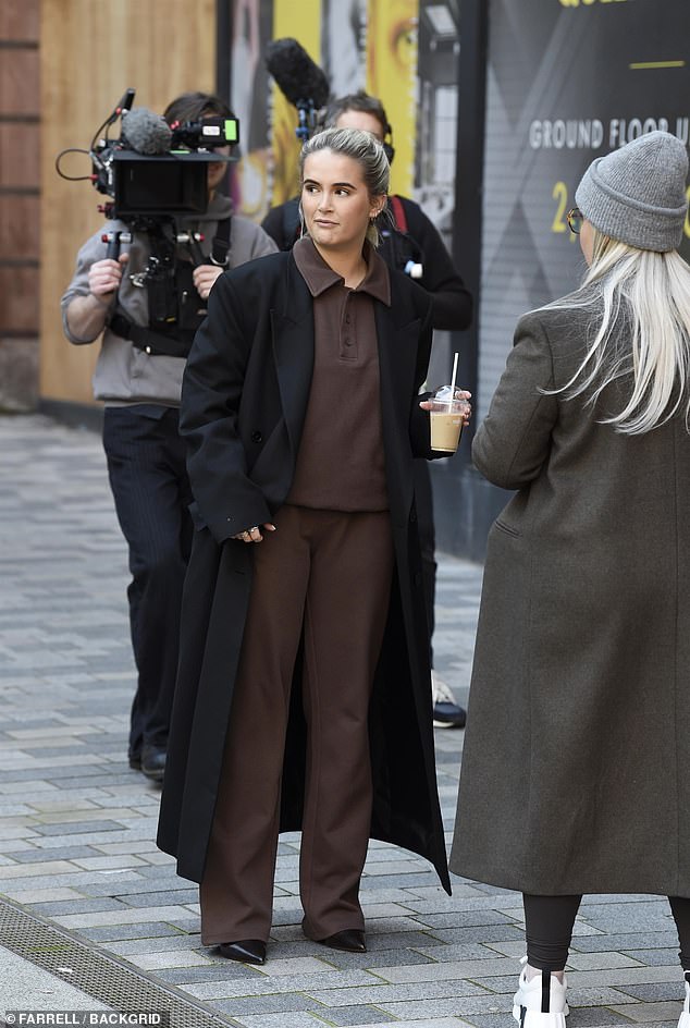 Predajući besplatnu kavu i slatke poslastice na trgu Lincoln u Manchesteru, YouTuber, 25, izgledao je elegantno u par visokih crnih stileta