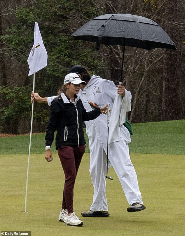 Kai's Caddy drži svoj kišobran dok se borila za borbu protiv svađe u kiši