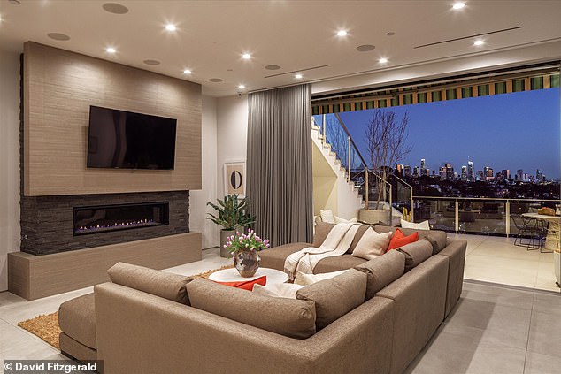 Dnevna soba ima veliki kamin ispod ugrađenog TV -a