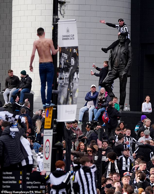 Navijač Newcastlea sjedi na ramenima kipa Sir Bobbyja Robsona izvan parka St. Jamesa '
