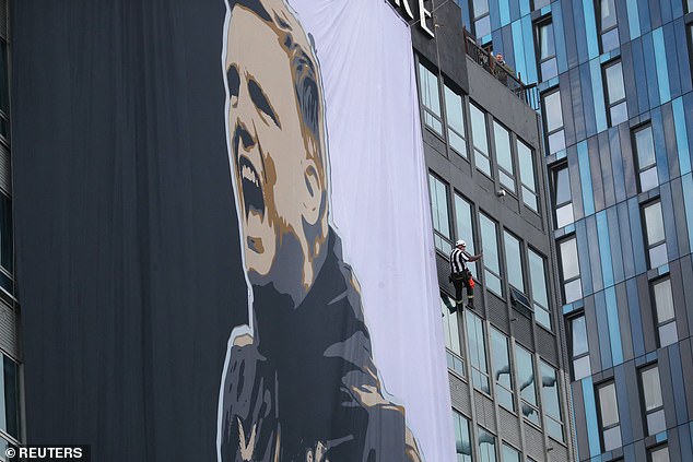 Radnik u Newcastle United Jerseyju pored gigantskog transparenta pobjedničkog menadžera Newcastlea Eddieja Howea