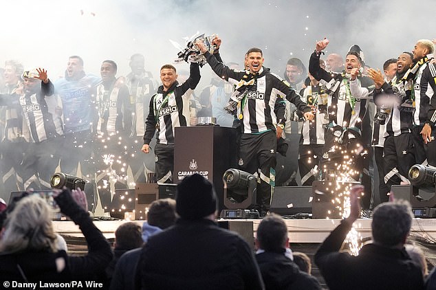 Newcastle kapetan Bruno Guimarães (desno) i branič Kieran Tripper drže trofej na proslavi pobjede kluba