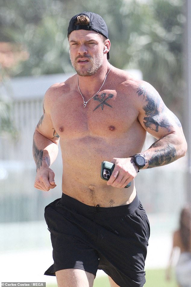 Alanova tonirana tjelesna tijela bila je na punom zaslonu dok je išao bez košulja zbog izleta, lepršavši njegov tetovirani torzo i biceps dok je trčao duž obale