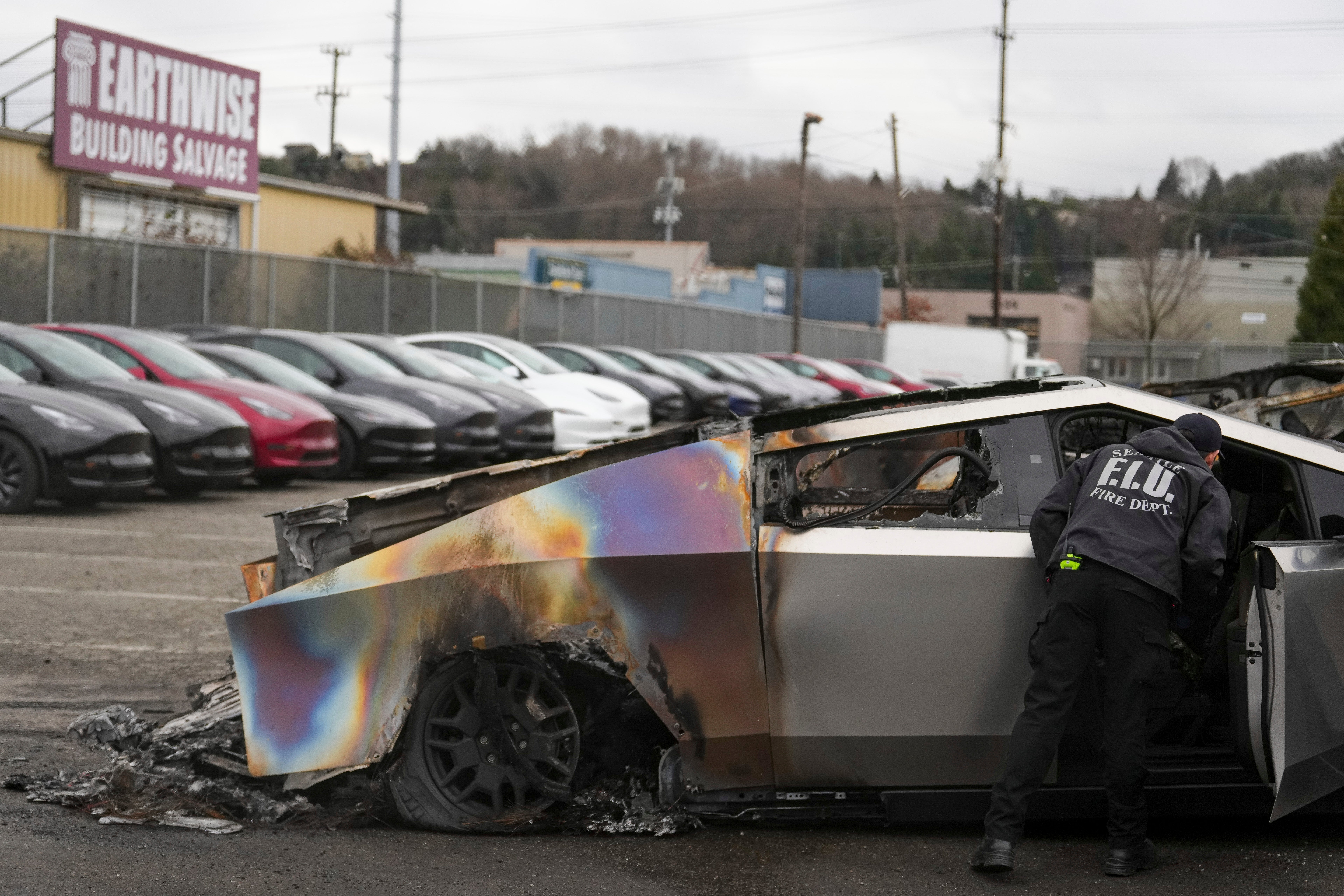 Član vatrogasne postrojbe u Seattlu pregledava spaljenu Tesla CyberTruck na lotu Tesla u Seattlu ranije ovog mjeseca