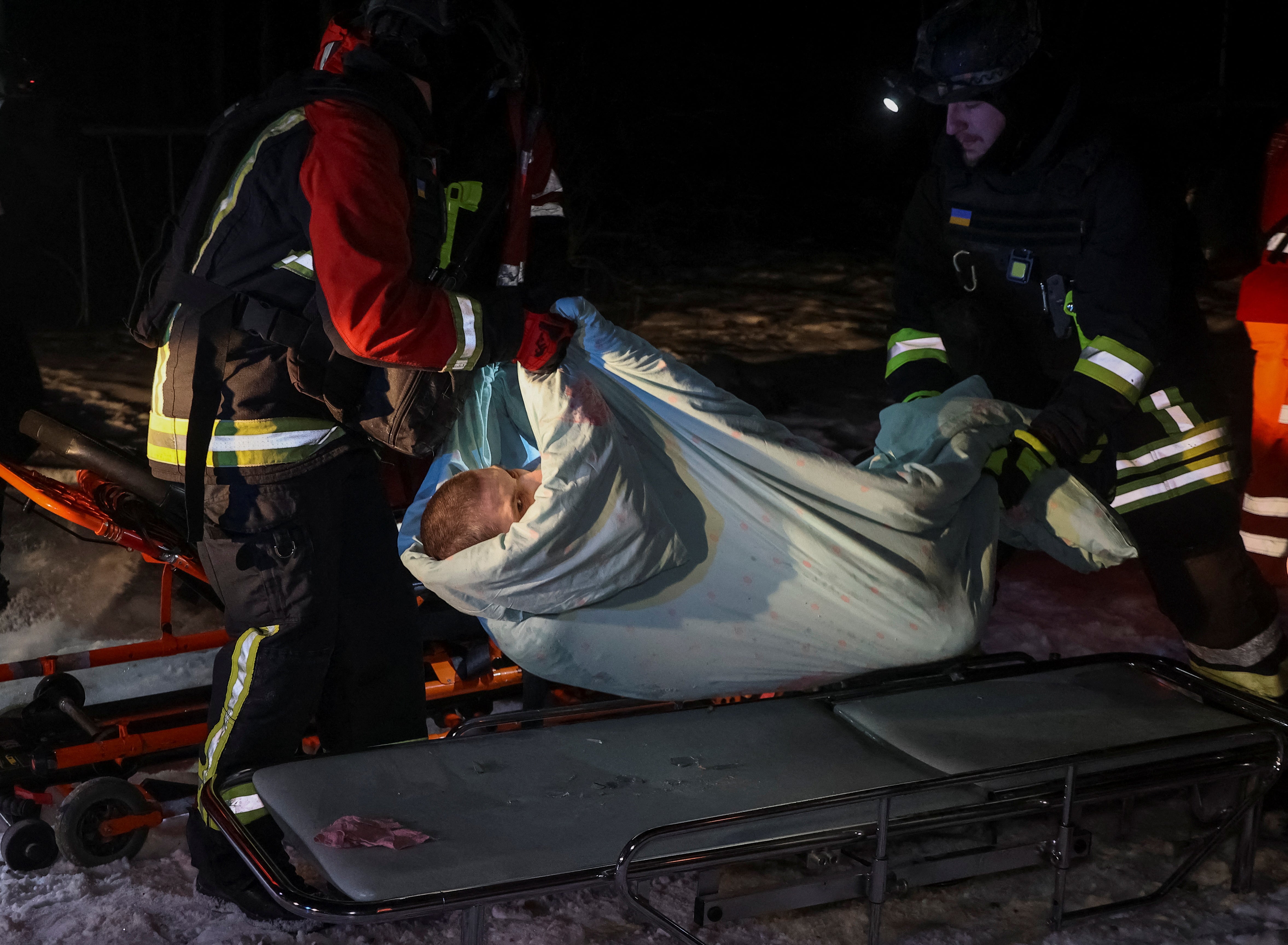 Spasioci i medicinski radnici evakuiraju osobu iz bolnice koju je pogodio ruski štrajk bespilotnih letjelica, usred napada Rusije na Ukrajinu, u Harkivu