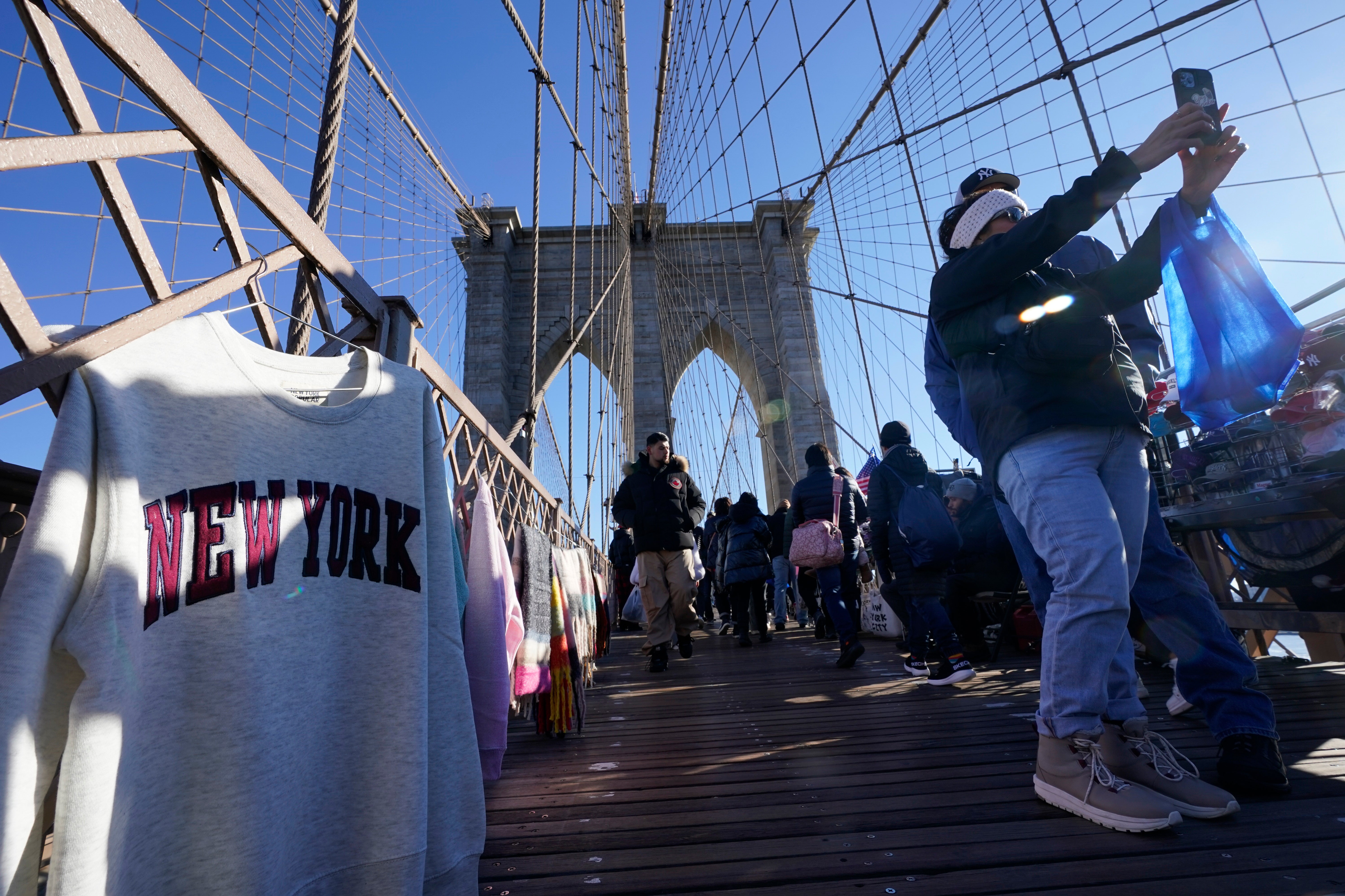 Turisti koji hodaju poznatim njujorškim mostom Brooklyn